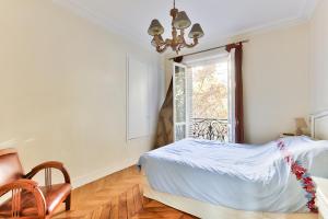 Schlafzimmer mit einem Bett und einem Fenster in der Unterkunft Appartement 140m2 proche des Champs Elysées in Paris