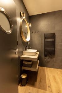 a bathroom with a sink and a mirror at Ubytovanie na Tokaji Empora Apartman in Veľká Tŕňa