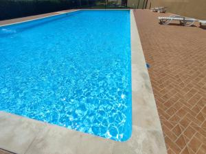 uma piscina com água azul num edifício em Bayside Holiday Home em São Martinho do Porto