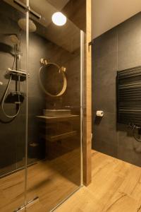 a bathroom with a glass shower with a mirror at Ubytovanie na Tokaji Empora Apartman in Veľká Tŕňa