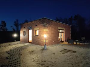 a brick building with a light in front of it at night at Mamucia Chata in Kaszuba