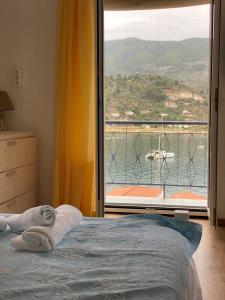 a bedroom with a bed and a large window at Veranta Vosporos in Poros
