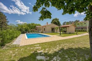 un patio trasero con piscina y una casa en Villa Alba with Private Pool, en Lupoglav