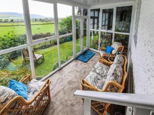 a screened in porch with chairs and a couch at Glenesk in Snitter