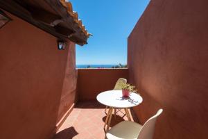 Una mesa y sillas en un balcón con vista al mar. en Home2Book Ocean Surf House Fuerteventura, en La Oliva