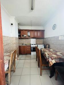 a kitchen with a table and chairs in a room at Guest House Velania in Pristina