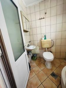 y baño con aseo y lavamanos. en Guest House Velania, en Pristina