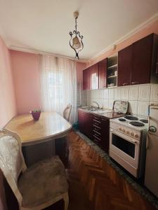 a kitchen with a table and a stove at Guest House Velania in Pristina