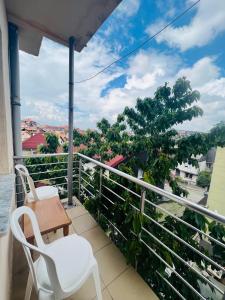 a balcony with two chairs and a view of a city at Guest House Velania in Prishtinë
