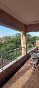 balcón con mesa, sillas y vistas en Mmathaba Guest House en Mmadinare