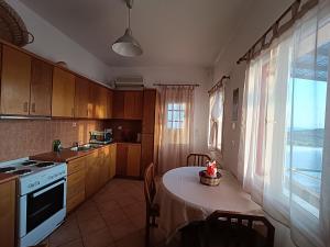 a kitchen with a table and a stove and a window at Sea view Cycladic house in Tinos