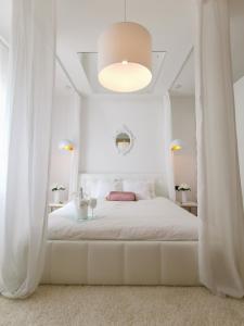 Donji Babići的住宿－Villa Santo，白色卧室配有一张带白色窗帘的大床