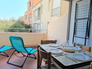 een tafel en stoelen op een balkon met uitzicht bij Appartement Cap d'Agde, 1 pièce, 4 personnes - FR-1-249-20 in Cap d'Agde