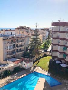 un apartamento con piscina frente a algunos edificios en Luminoso apartamento Playa Torrecilla. Con Piscina, en Nerja