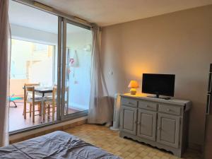 een slaapkamer met een bed en een televisie op een dressoir bij Appartement Cap d'Agde, 1 pièce, 4 personnes - FR-1-249-20 in Cap d'Agde
