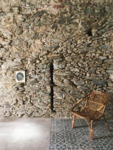 a chair sitting in front of a stone wall at Traditional House (renovated) 150m from the sea in Roses