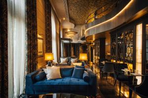 a living room with a blue couch and chairs at Hotel Bagués, a Small Luxury Hotel of the World in Barcelona