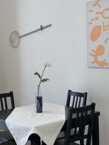 Sardinian Gallery Corso في بوسا: طاولة مع مزهرية عليها زهرة