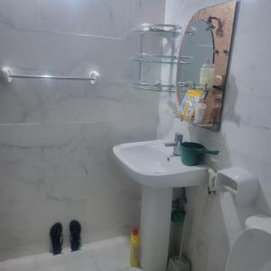 W białej łazience znajduje się umywalka i lustro. w obiekcie Baraste zanzibar w mieście Ngambo