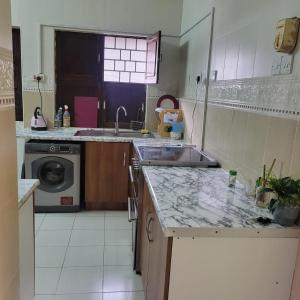 a kitchen with a sink and a washing machine at Baraste zanzibar in Ngambo