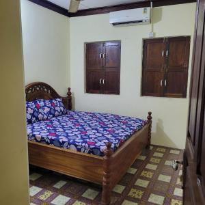 sypialnia z drewnianym łóżkiem w pokoju w obiekcie Baraste zanzibar w mieście Ngambo