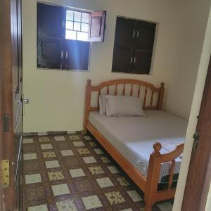 een kleine slaapkamer met een bed en een raam bij Baraste zanzibar in Ngambo