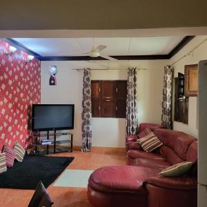 Il comprend un salon doté d'un canapé et d'une télévision à écran plat. dans l'établissement Baraste zanzibar, à Ngambo