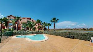 a swimming pool in front of a fence with palm trees at Casa Espliego A-Murcia Holiday Rentals Property in Torre-Pacheco