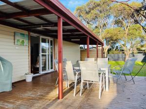 a patio with a table and chairs on a deck at Teddy's Shack - Pet Friendly in Robe