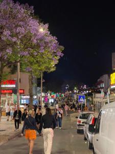 a group of people walking down a street at night at Guest House Casa Ramos on the Strip in Albufeira +58 photos