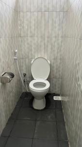 a bathroom with a white toilet in a stall at OLMOTI SUITES in Arusha