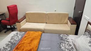 a living room with a couch and a bed at Gaurang Homestay in Vadodara