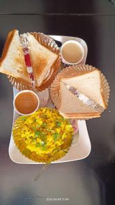 巴羅達的住宿－Gaurang Homestay，上面有三明治和鸡蛋的白盘
