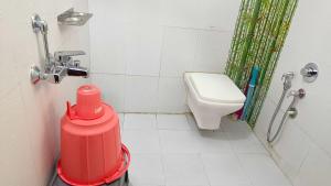 a bathroom with a toilet and a red trash can at Gaurang Homestay in Vadodara