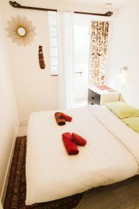 a bedroom with two red mittens on a bed at Cozy room on the beach in La Ciotat