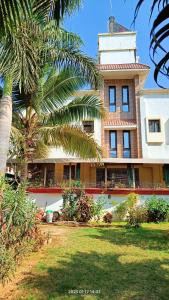 巴羅達的住宿－Gaurang Homestay，前面有棕榈树的建筑