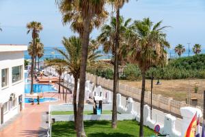 a view of a resort with palm trees and a swimming pool at Charming apartment near beach, sea view terrace in Torremolinos