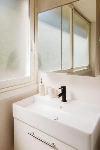 ein Badezimmer mit einem weißen Waschbecken und einem Spiegel in der Unterkunft Cozy room on the beach in La Ciotat