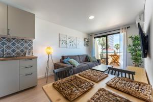 un soggiorno con tavolo e divano di Charming apartment near beach, sea view terrace a Torremolinos