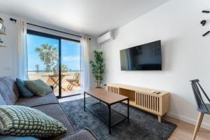 a living room with a couch and a tv at Charming apartment near beach, sea view terrace in Torremolinos