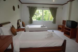 a bedroom with two beds and a television in it at Chaweng Tara Hotel in Chaweng Noi Beach