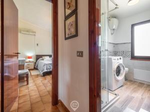 uma casa de banho com máquina de lavar e secar roupa num quarto em Matilde Graceful House em Capitana