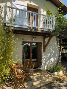 uma casa com uma varanda e duas cadeiras de madeira em gîte de Fontjalabert en campagne tout confort em Lisle-sur-Tarn