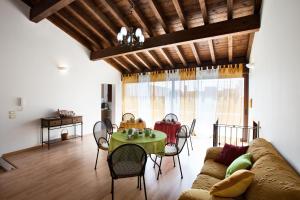 uma sala de estar com um sofá e uma mesa com cadeiras em B&B Perla del Sud em Collepasso