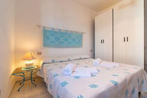 una camera con letto e tavolo con lampada di La Lampara - Casa Panoramica 4 Km dalla Pelosa a Stintino