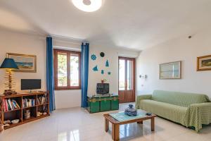 un soggiorno con divano e tavolo di La Lampara - Casa Panoramica 4 Km dalla Pelosa a Stintino