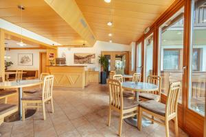 eine Küche und ein Esszimmer mit Tischen und Stühlen in der Unterkunft Hotel Gesser in Sillian