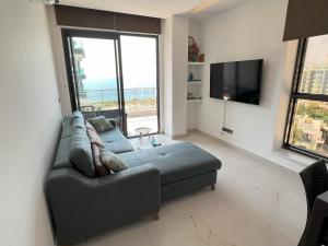 uma sala de estar com um sofá e uma televisão de ecrã plano em Résidence Boutique XV Alanya Bay, Vue exceptionnelle sur Mer em Kargicak