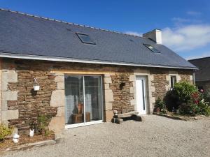 una casa de ladrillo con ventana y aphalt en Les gîtes de L'hermine, en Plouigneau