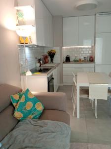 a living room and kitchen with a couch and a table at Złoty apartament Bokserska in Warsaw